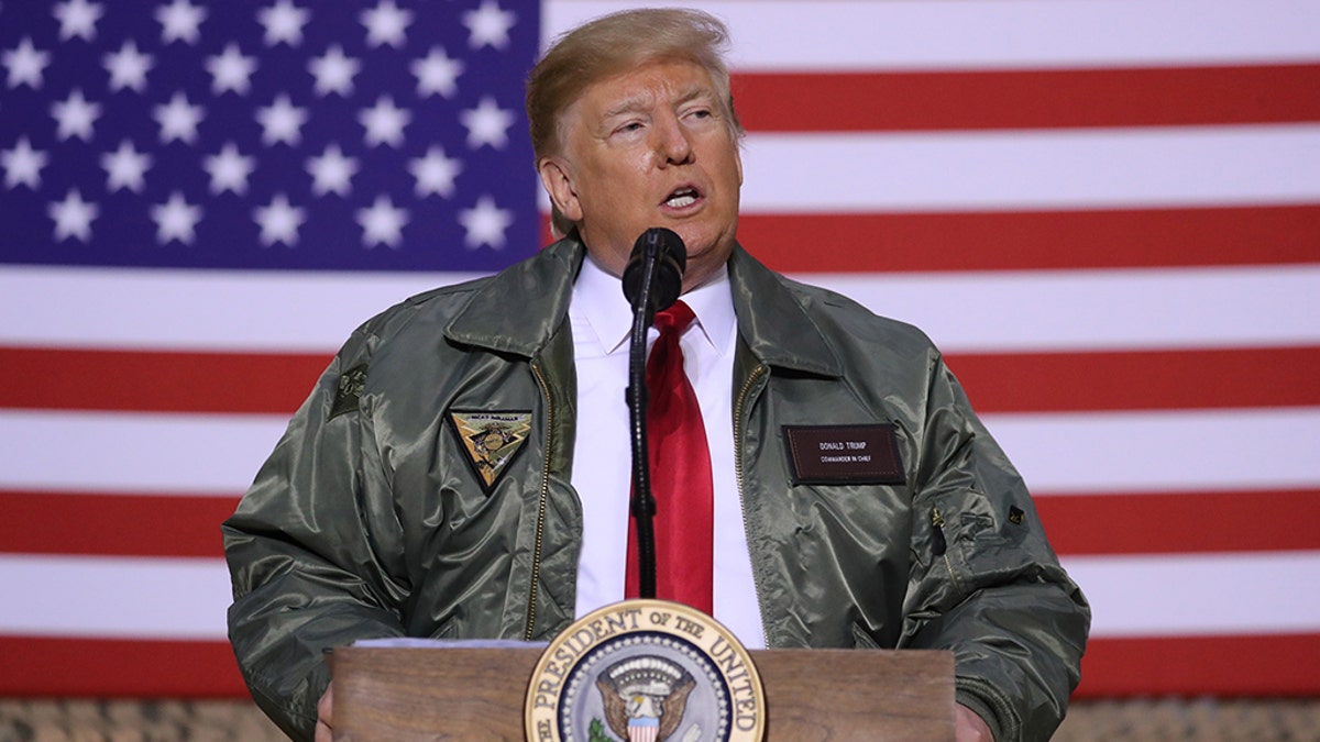 Donald Trump in bomber jacket in 2018 speaking to US troops