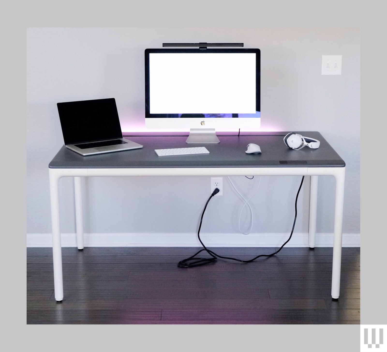 Beflo Tenon Premium Standing Desk with grey top and white legs that has a computer laptop keyboard computer mouse and...