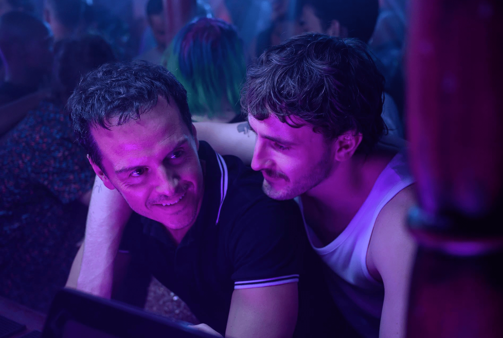 Andrew Scott and Paul Mescal in a crowded club with purple lighting.
