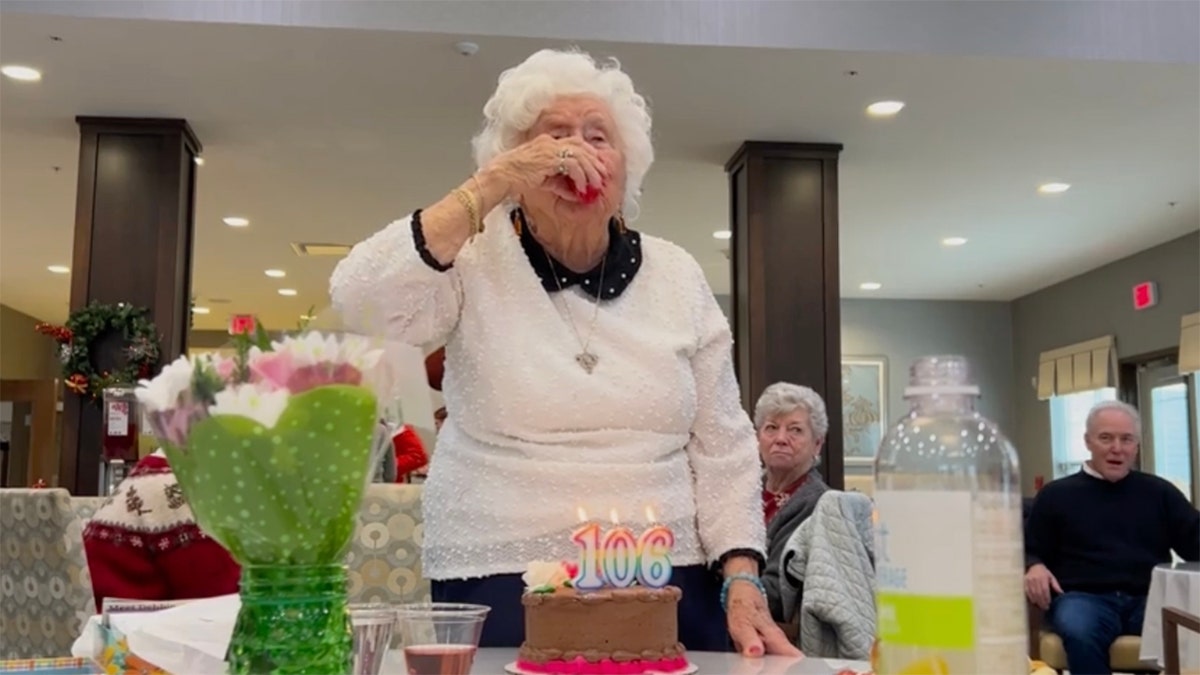 Flo with a shot of fireball behind a cake reading 106.