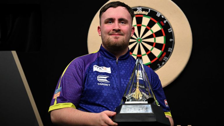 Luke Littler celebrates with the Premier League Darts trophy
