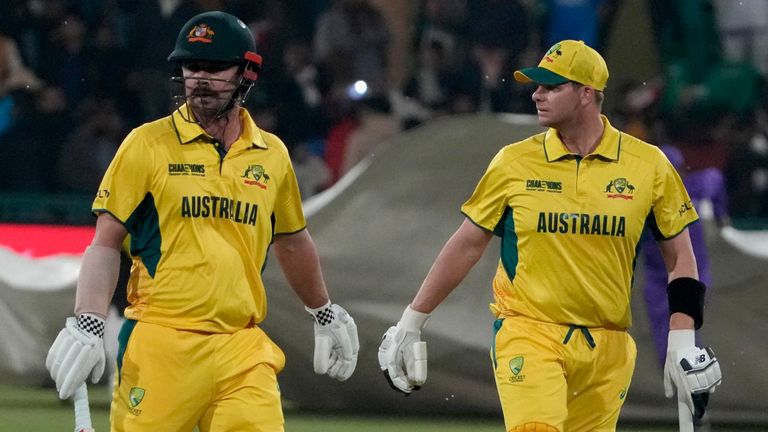 Australia's Steve Smith, right, and Travis Head walk off the field after rain stops the play in Lahore