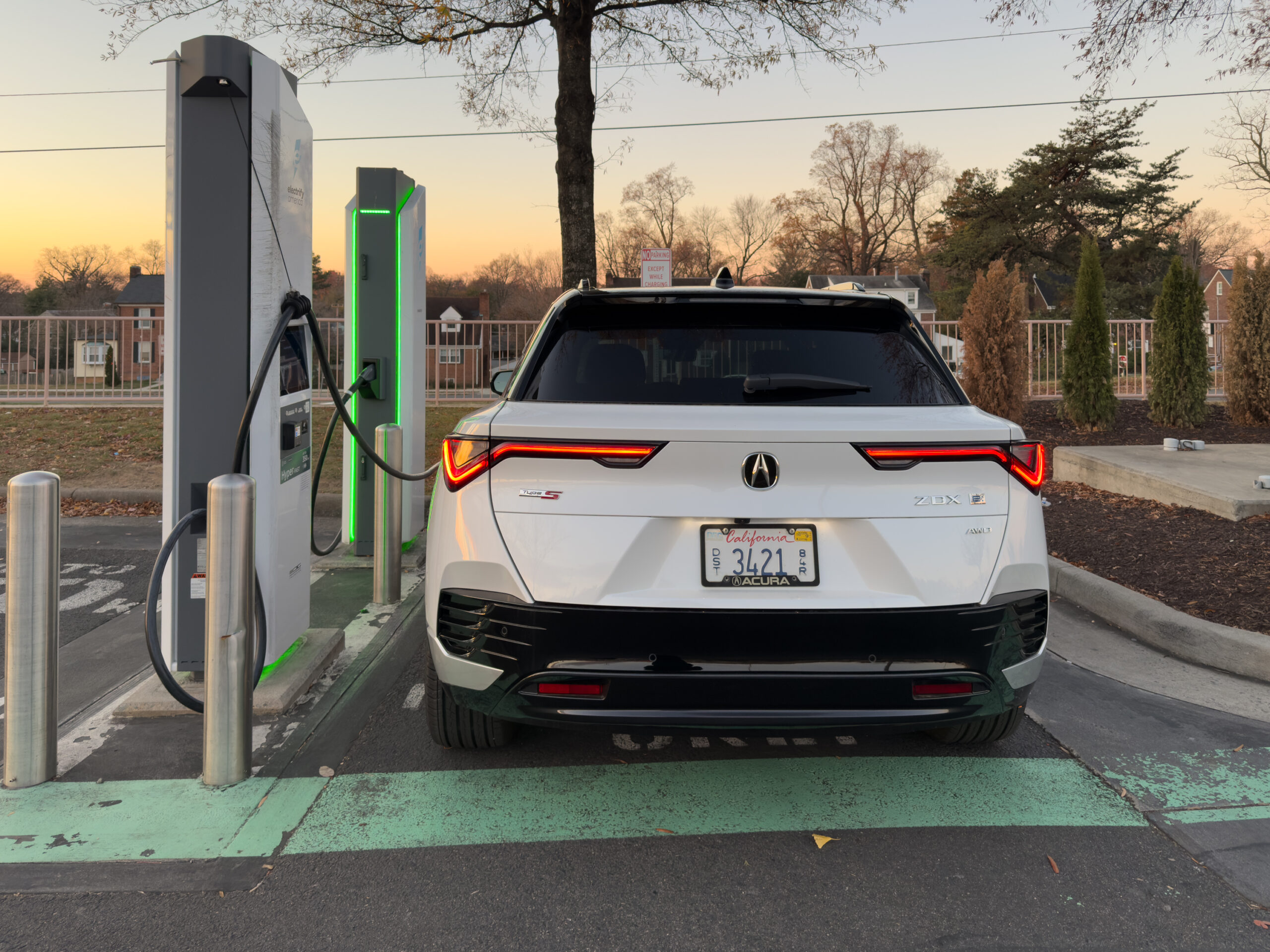 A white Acura ZDX, charging at an electrify America station.