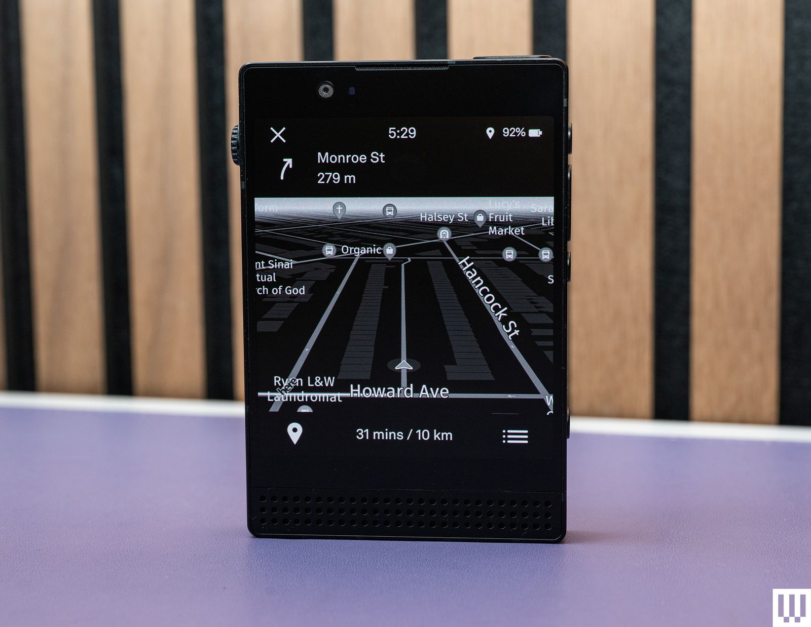 Front view of Light Phone III a small black squareshaped device with the screen showing a black and white navigation map