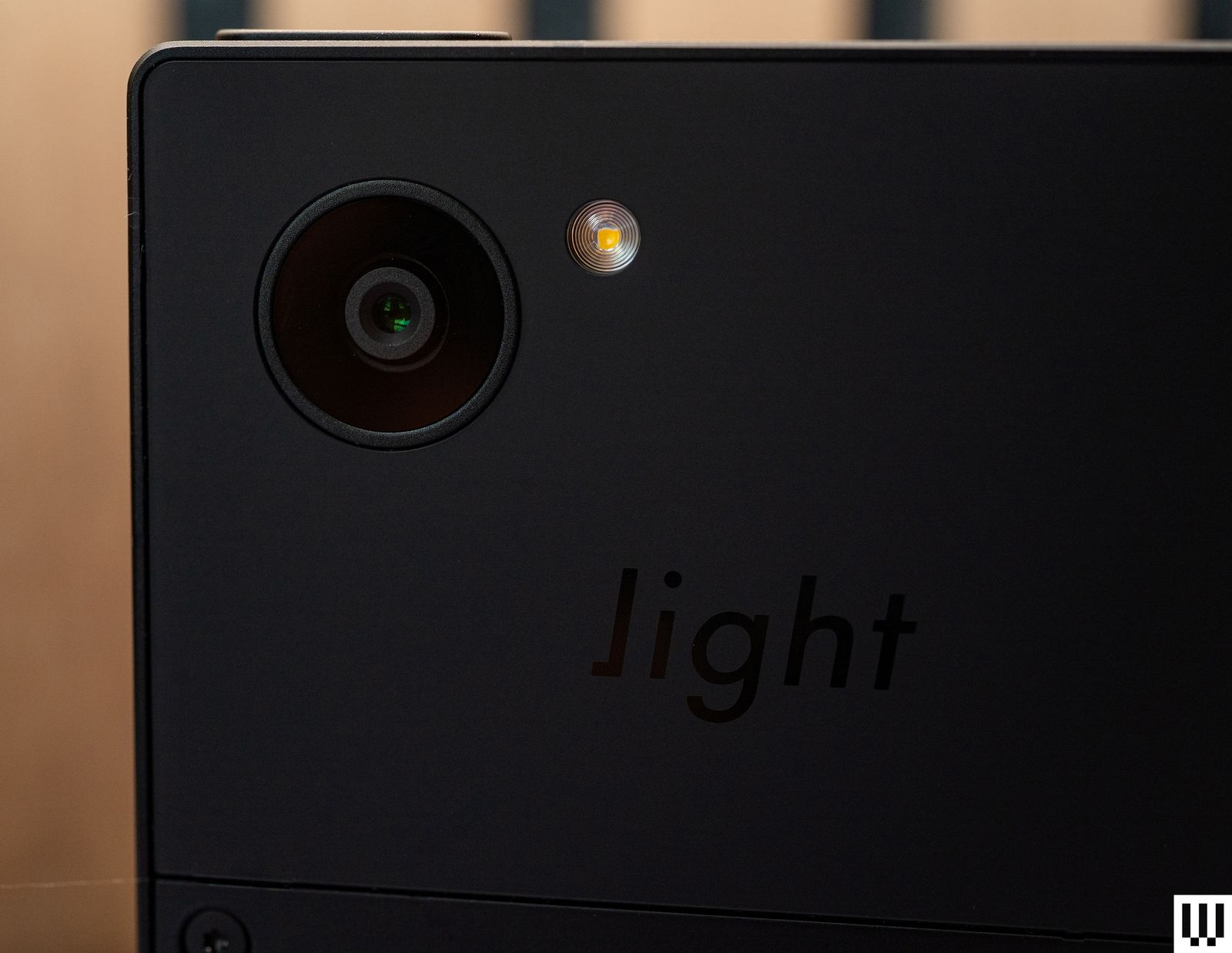 Rear view of Light Phone III a small black squareshaped device with a camera on the back