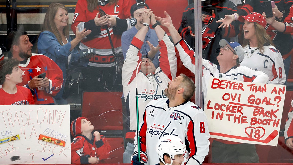 Alex Ovechkin flips a puck to fans