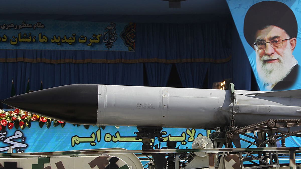 A military truck carries a missile past a portrait of Iran's Supreme Leader Ayatollah Ali Khamenei during an annual military parade.