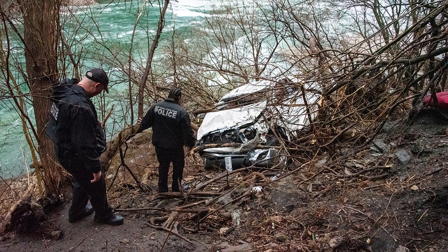 Authorities approach a crashed vehicle in Niagara Gorge