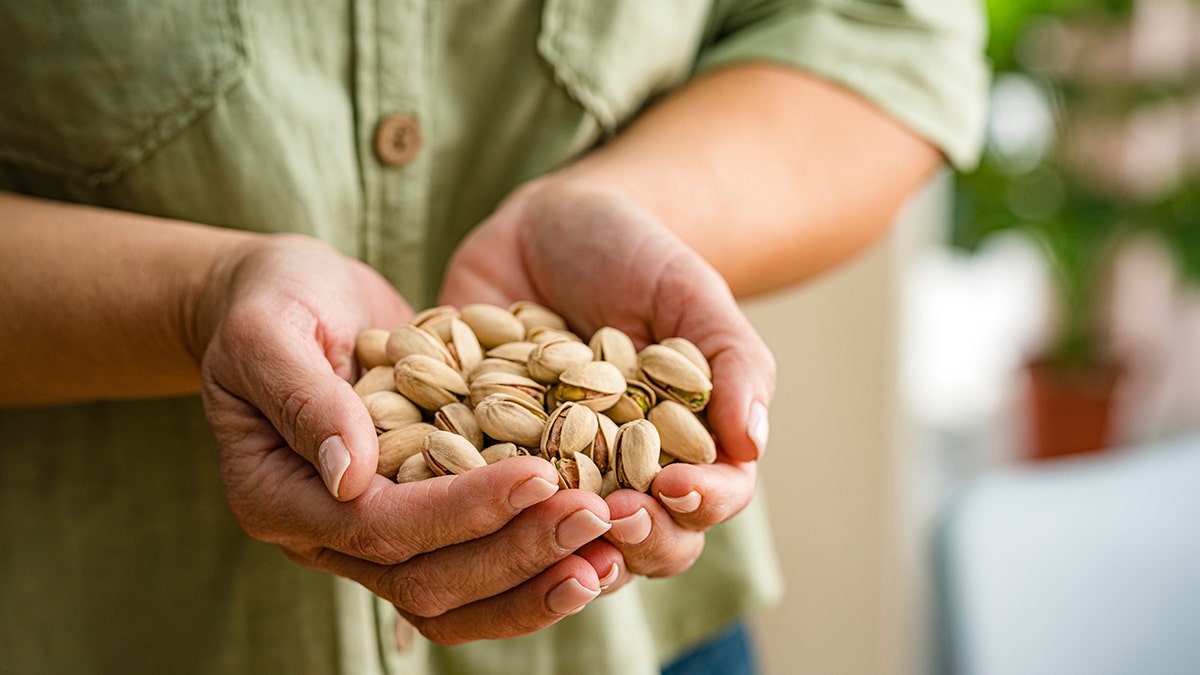 hands holding pistachio nuts