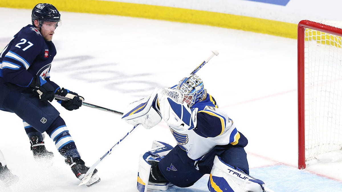 Jordan Binnington tries to save puck