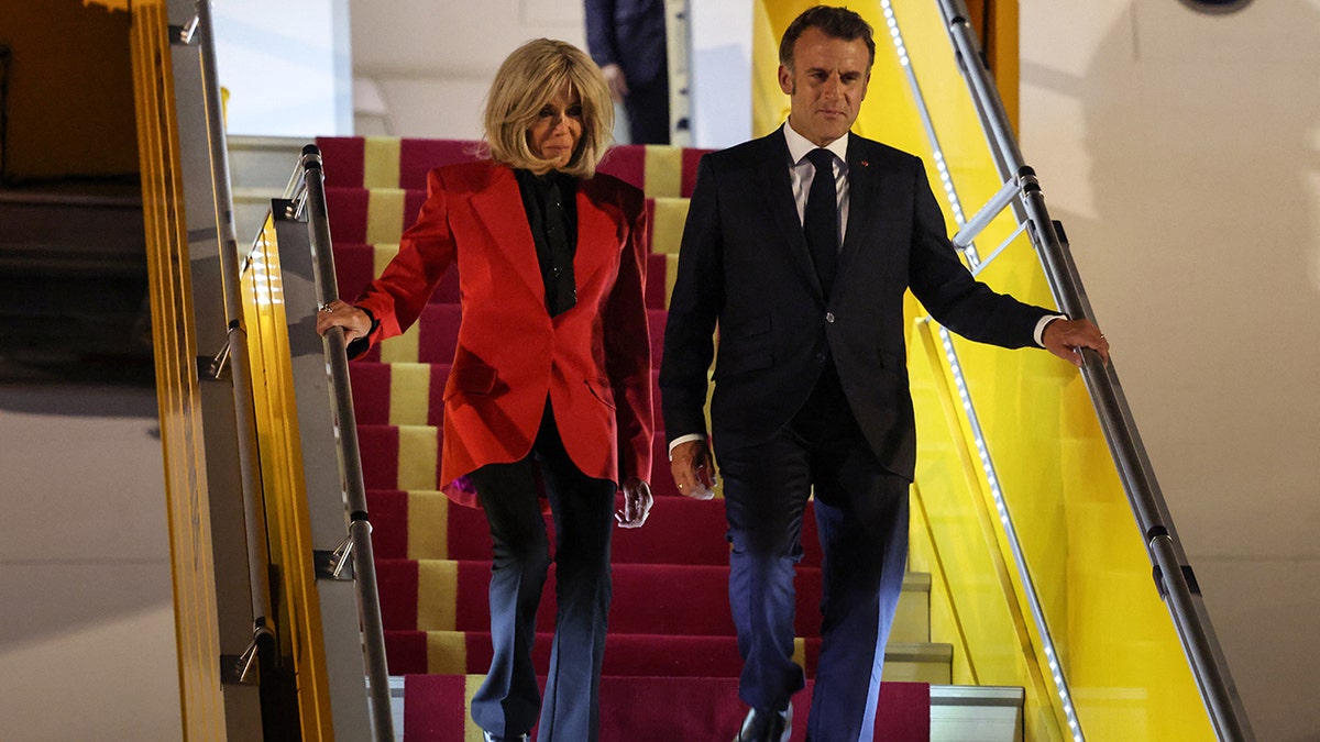 Emmanuel and Brigitte Macron disembark plane after face grabbing