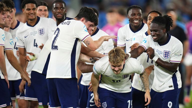 England's Jonathan Rowe, right, pats teammate Harvey Elliott, center, at the end of the European U-21 Championship final soccer match between England and Germany at the National Football Stadium in Bratislava, Slovakia, Saturday, June 28, 2025. (AP Photo/Petr David Josek)