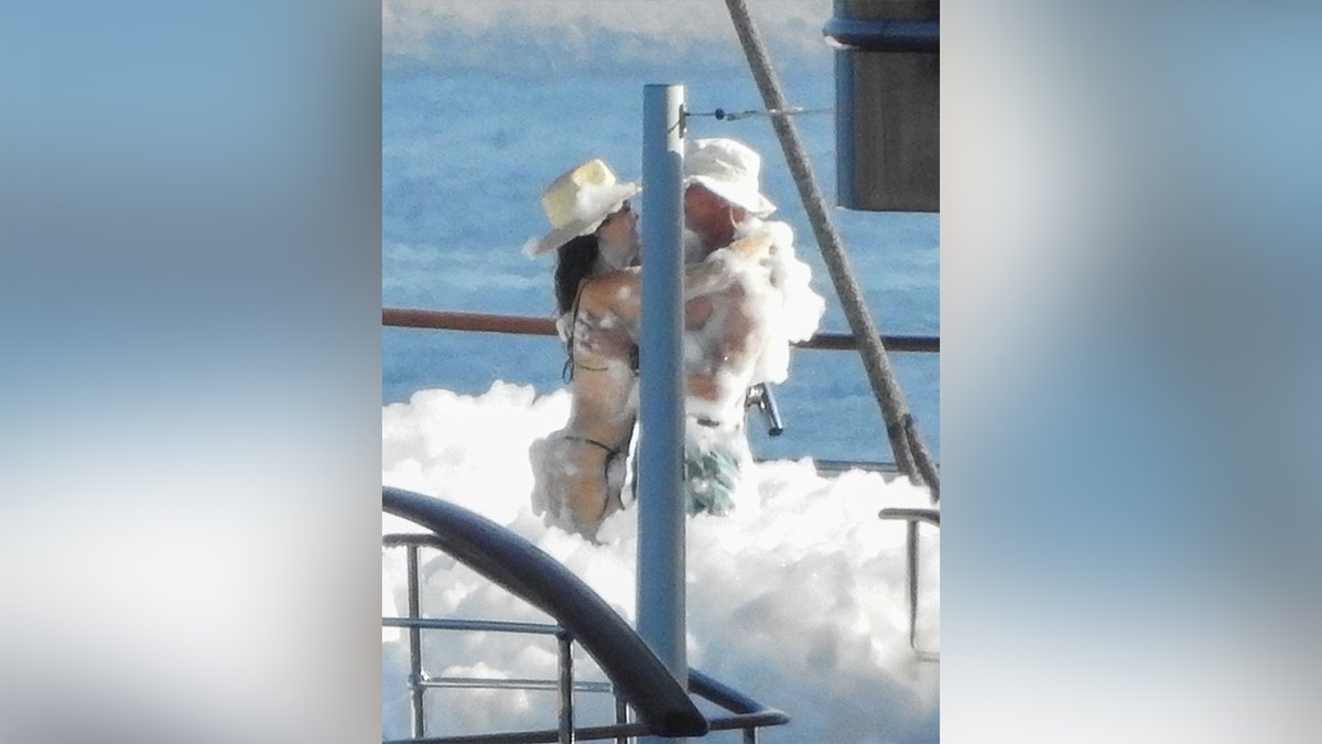 Jeff Bezos and Lauren Sanchez hugging during a foam party on his yacht.