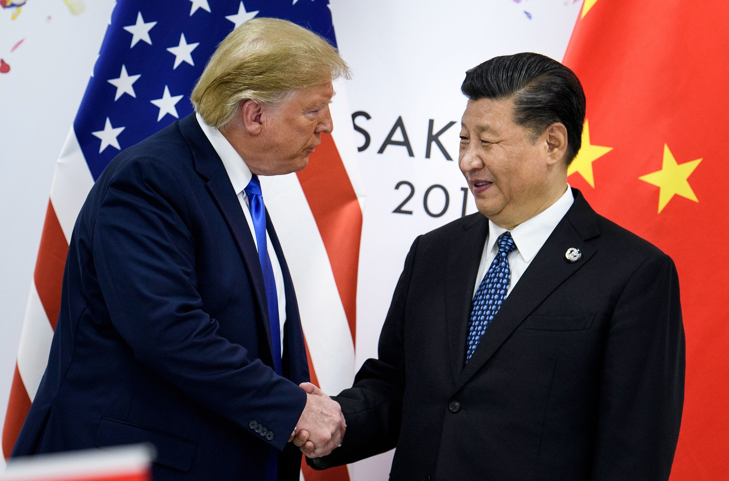 China’s President Xi Jinping (R) shakes hands with US President Donald Trump on June 28, 2019 before a bilateral meeting on the sidelines of the G20 Summit in Osaka. 