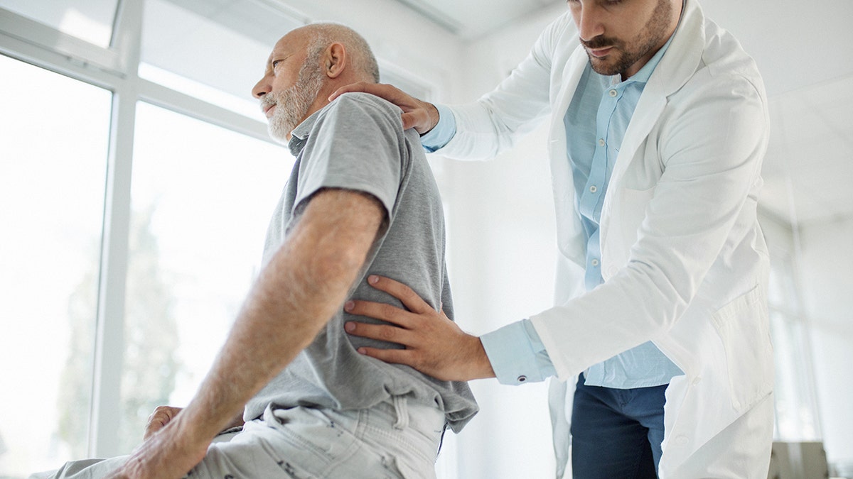 man having his spine examined at doctor's office