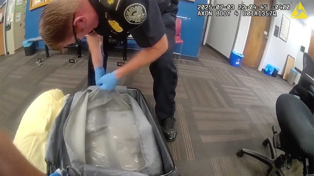 Atlanta Police Department officer searches luggage