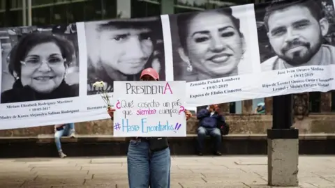 Reuters A woman holds a sign reading "President, what does a country that sows bodies harvest?" during a protest marking the International Day of the Victims of Enforced Disappearances, in Mexico City