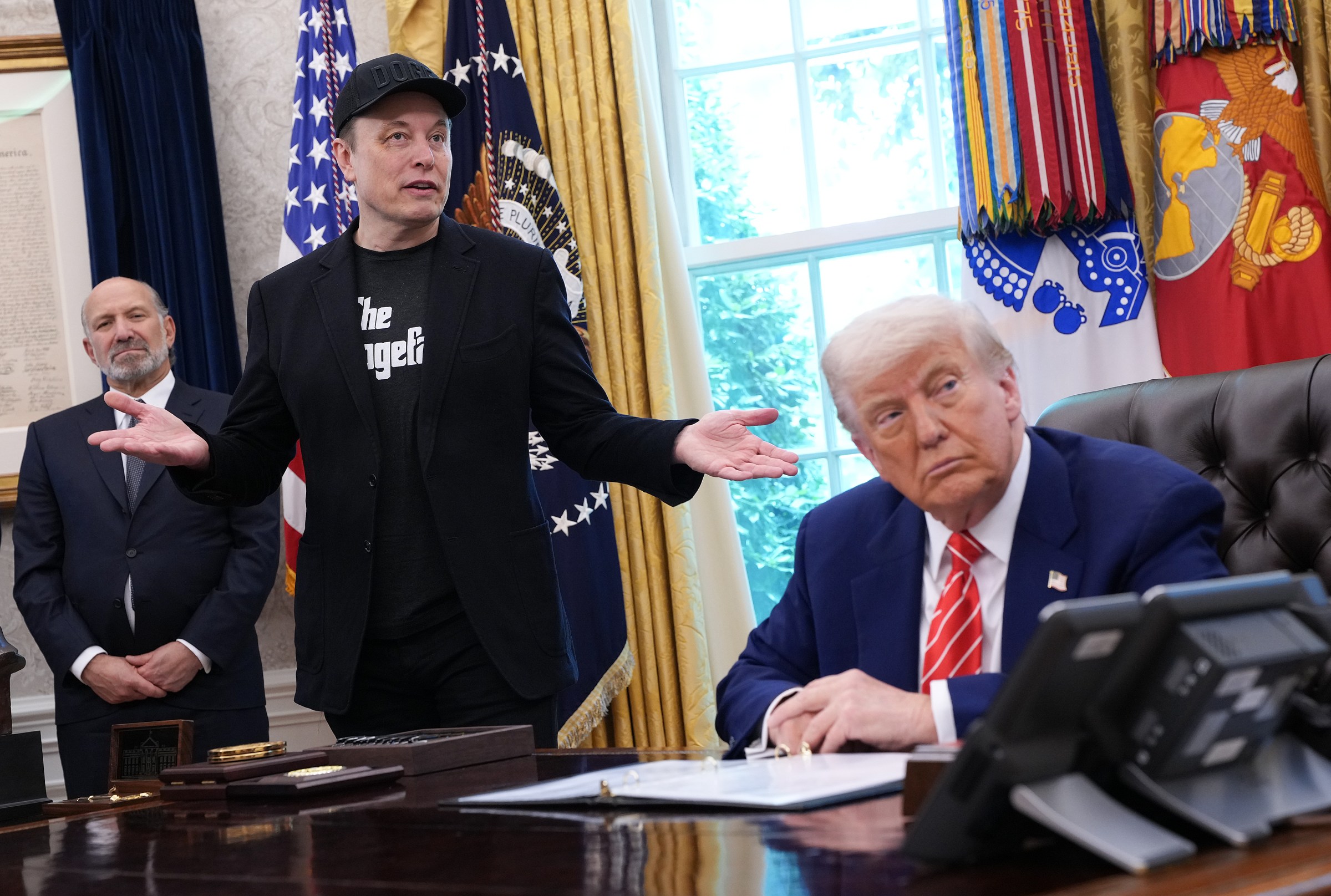 In the Oval Office, Trump sits at his desk with Elon Musk beside him