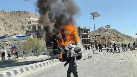 Reuters A vehicle is set on fire during a protest by locals demanding statehood for the federal territory and job quotas for local residents in Leh, in the Ladakh region, India, on 24 September 2025