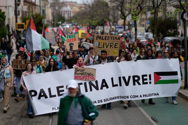 People carry a banner with the words "Free Palestine" during a demonstration demanding a cease fire in Gaza and in support of Palestinians, in Lisbon, Sunday, April 7, 2024. (AP Photo/Armando Franca)
