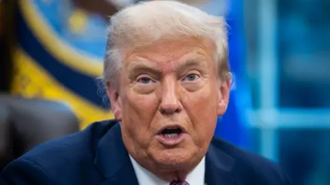 EPA Donald Trump speaks wearing a suit in the Oval Office. 