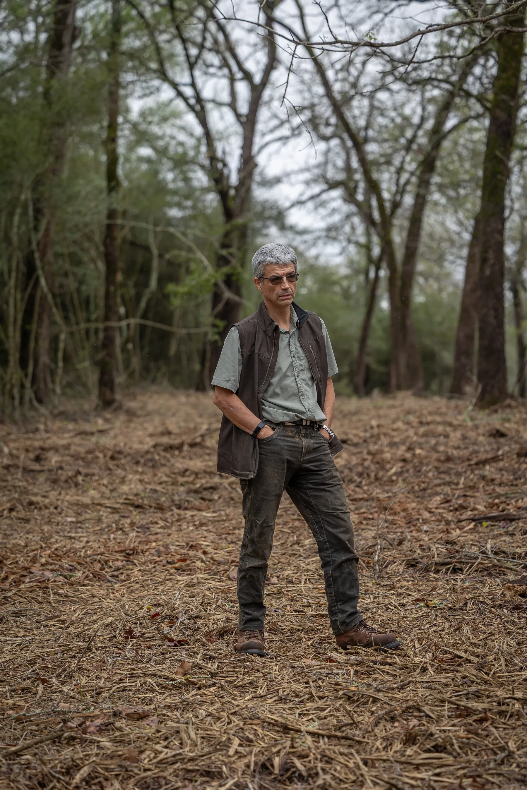 A man stands in a clearing on his 190-acre property