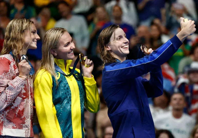 Ariarne Titmus, Summer McIntosh and Katie Ledecky react.