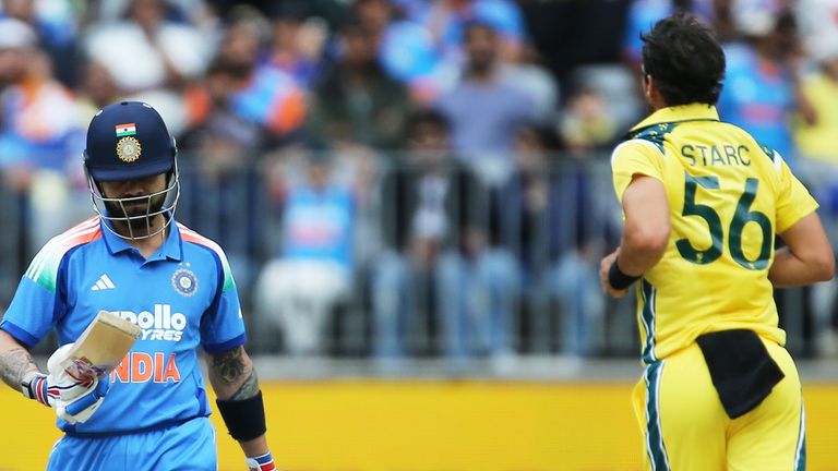 India's Virat Kohli, left, walks off after being dismissed by Australia's Mitchell Starc during the one day international cricket match 