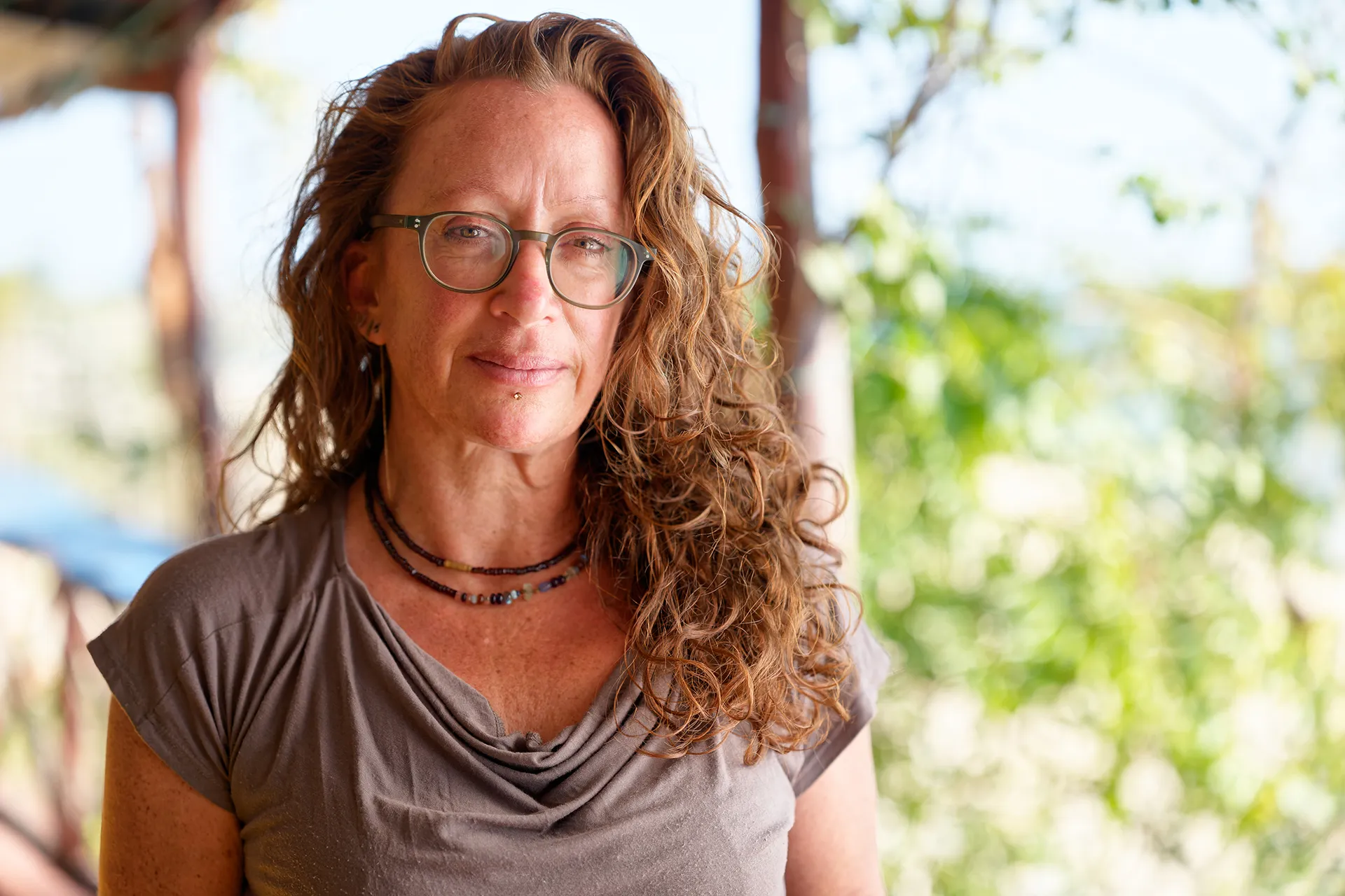 Emma Gibbons wears glasses and has long curly reddish hair.