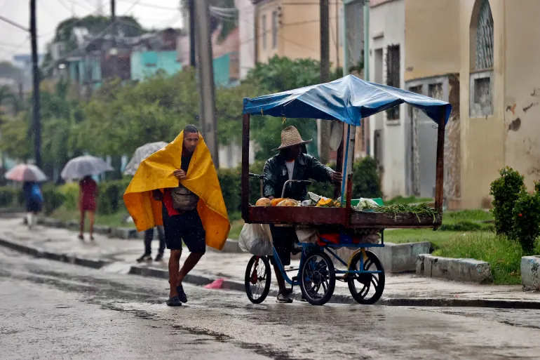 epa12488824 People shelter from the rain in Santiago de Cuba, Cuba, 28 October 2025. Cuba's Institute of Meteorology (Insmet) predicts that Melissa will hit the eastern tip of the island as an 'extremely dangerous' hurricane, predicting a category 4 (out of 5) on the Saffir-Simpson scale. EPA/Ernesto Mastrascusa