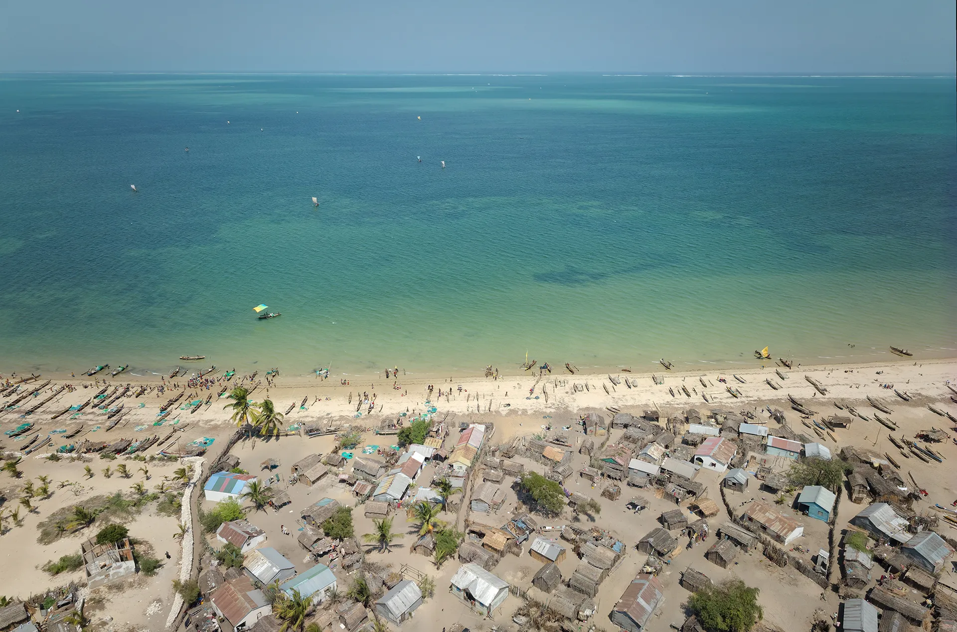 An aerial view of turqouise water and homes