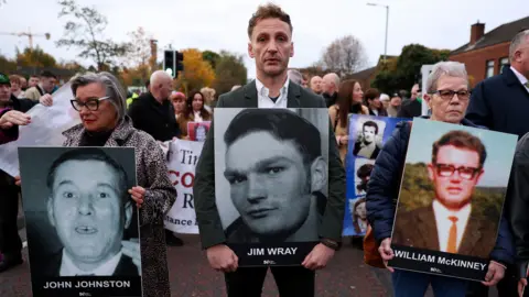 Reuters A crowd gathers in the street holding placards with family members 