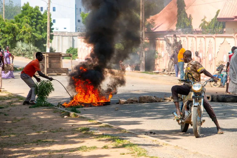 Burning barricades are seen in Garoua during a demonstration by supporters of the political opposition on October 21, 2025 ahead of the release of the results of the presidential vote. (Photo by AFP)