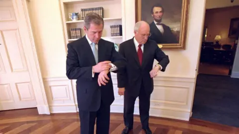 Getty Images George W Bush and Dick Cheney check their watches in the Oval Office