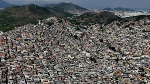 Reuters A drone view shows densely packed homes in the Penha favela complex, where the country's deadliest security operation in modern Brazilian history against drug trafficking was executed, in Rio de Janeiro, Brazil, November 4, 2025.
 A warren of small houses can be made out against the backdrop of green hills. 