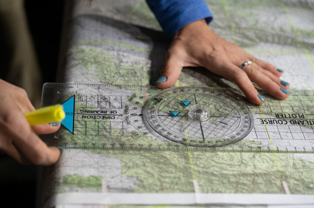 hands hold a compass on a map