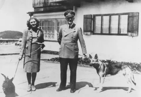 Getty Images Hitler and a woman, each holding a dog on a leash.