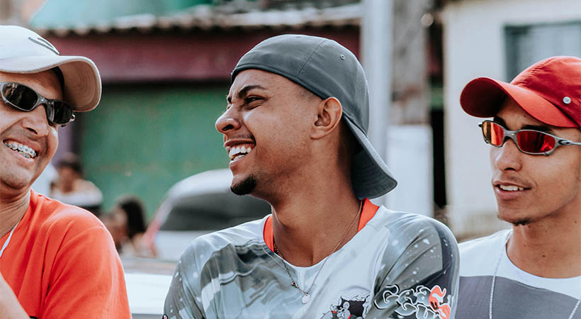 Three brazilian men laughing wearing caps