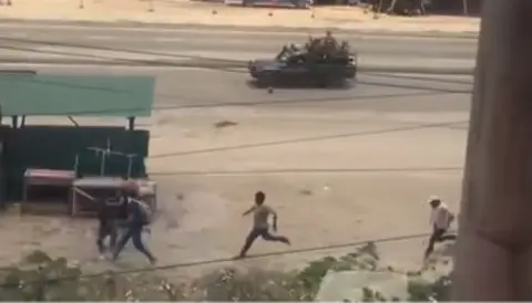 Douyin Men running along a road chased by an open backed vehicle with armed police