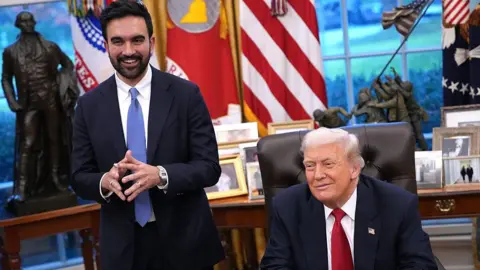 Getty Images President Donald Trump and New York City Mayor-Elect Zohran Mamdani smile as they take questions from the press in the Oval Office.