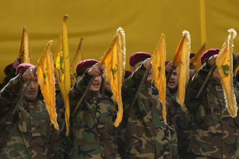 Hezbollah fighters raise their group's flags and chant slogans as they attend the funeral procession of Hezbollah's chief of staff, Haytham Tabtabai, and two other Hezbollah members who were killed in Sunday's Israeli airstrike, in a southern suburb of Beirut, Lebanon, Monday, November 24, 2025. [Hussein Malla/AP]