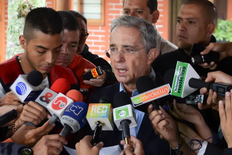 Alvaro Uribe speaks to reporting scrum