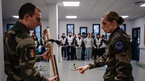 AFP via Getty Images Military instructors provide guidance to participants during a laser shooting training session in France