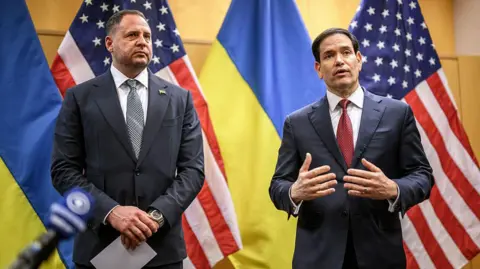 Getty Images US Secretary of State Marco Rubio (R) and Ukraine's Presidential Office Chief of staff Andriy Yermak hold a press conference following their closed-door talks on a US plan to end the war in Ukraine at the US Mission in Geneva, on November 23, 2025. US Secretary of State Marco Rubio arrived in Geneva on November 23, 2025 morning for discussions on a US plan to end the Ukraine war, after Washington signalled room for negotiation on the controversial proposal. Ukrainian, European and Canadian officials were also gathering in the Swiss city.