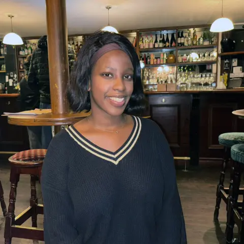 Amanda is standing in a pub