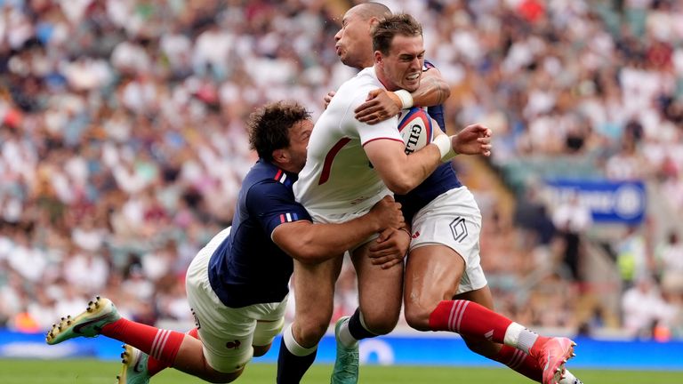 Tom Roebuck being tackled by two Frenchmen at Twickenham