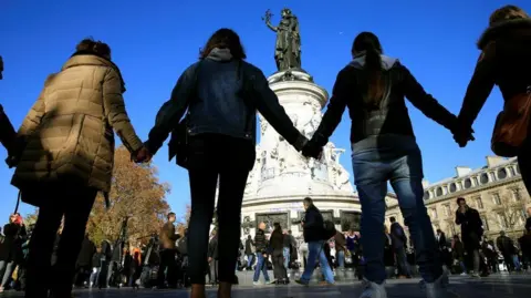 Reuters People hold hands to form a human solidarity chain near the site of the attack at the Bataclan concert hall in Paris, November 15, 201