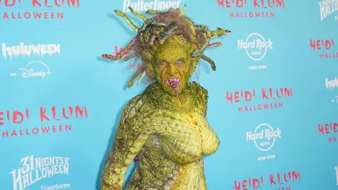 Getty Images Model Heidi Klum is in a green slithering Medusa costume complete with moving snakes on her head and a snake-like tongue. 