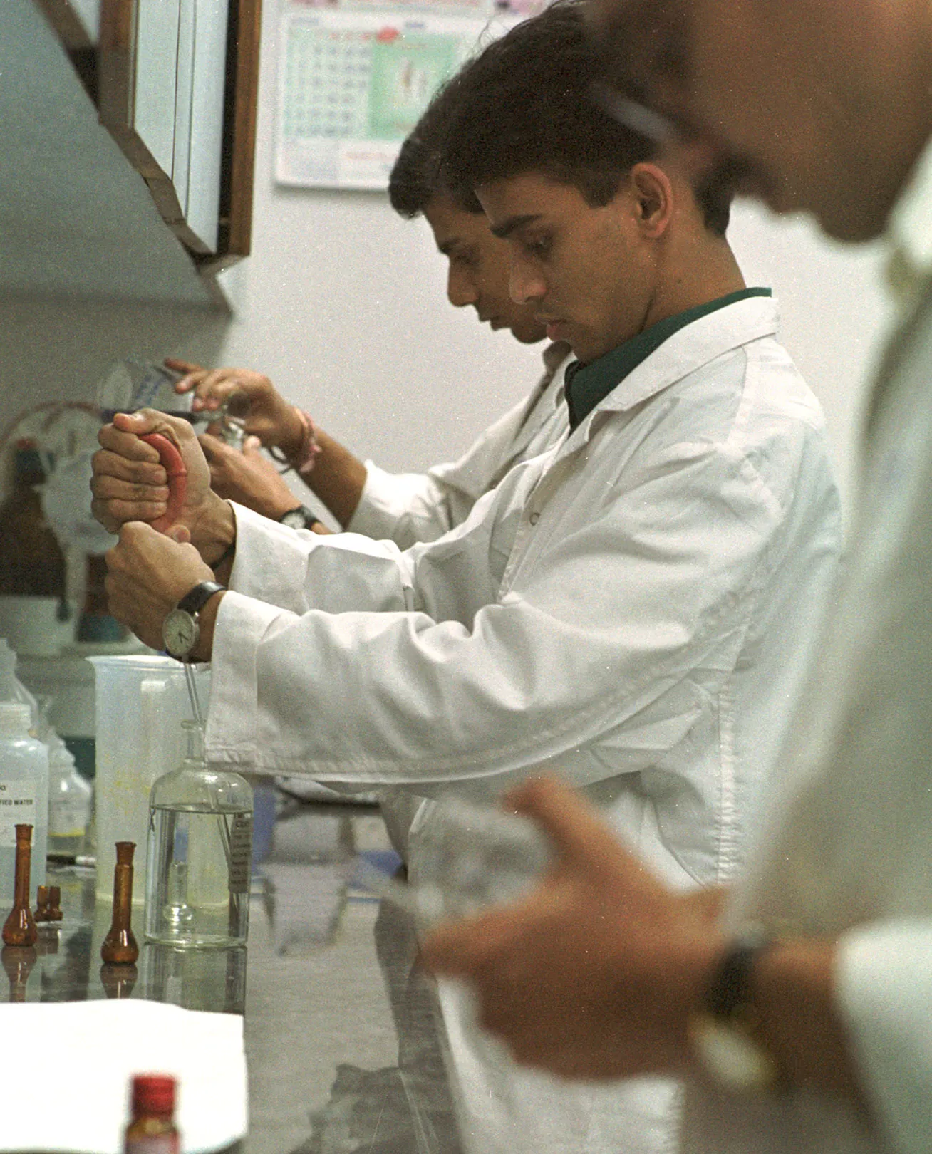Lab technicians in white coats test medicines at a Cipla quality-control laboratory in Mumbai.