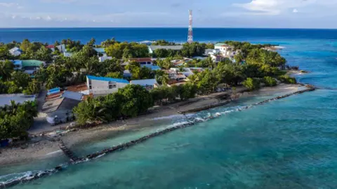 Getty Images Coastal picture of the Maldives, featuring turquoise blue seas which surround one of the archipelago's islands.